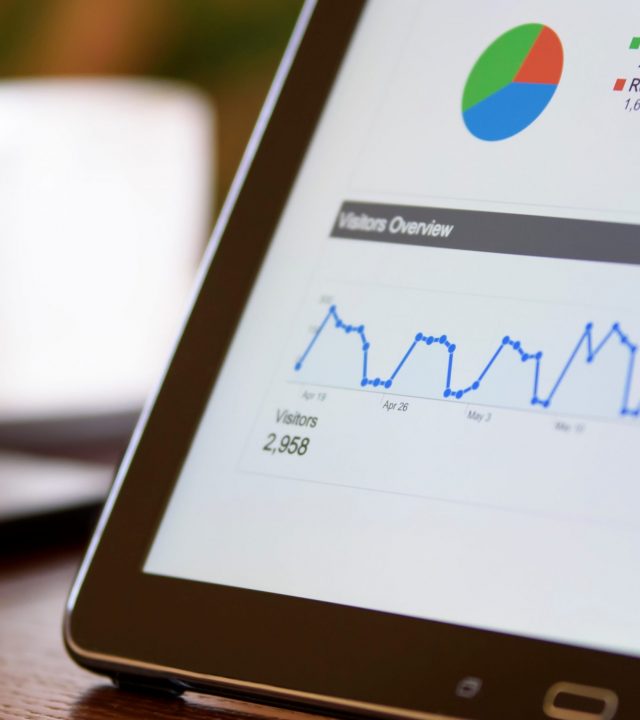 Business intelligence using modern technology Charts and analytical data on the tablet screen with a cup of coffee and a telephone in the background